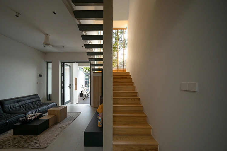 Cầu thang giữa các tầng có sự chuyển tiếp giữa chất liệu đá và gỗ, từ dạng kín sang thiết kế kiểu bay để đưa ánh sáng tiếp cận xuống không gian bên dưới.